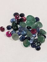 Loose faceted emerald, ruby and sapphire gemstones assorted shapes