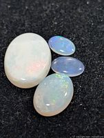 Four opal cabochons on black background