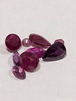 Loose faceted rubies grouped together, showing color and cuts