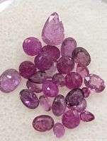 Cluster of loose faceted rubies showing color and cuts