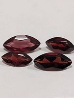 Four marquise-cut deep red sapphires