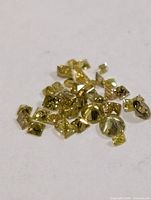 Pile of small yellow diamonds on white background