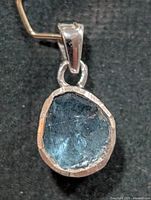 Front view of silver pendant showing blue diamond slice