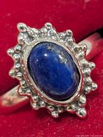 Front view of sterling silver lapis lazuli ring showing oval stone and beaded halo