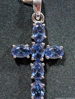 front view of silver cross pendant with seven tanzanite stones