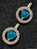 Front view of both earrings showing opal centres and stone halos