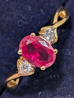 Top view of sterling silver ring showing created ruby center and accent stones