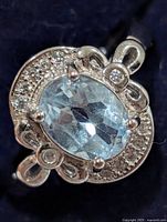 Front view of ring showing blue topaz, halo and accents