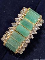 full view of emerald and clear stone silver ring