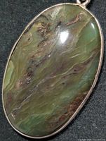 Front view of oval ocean jasper pendant in silver setting
