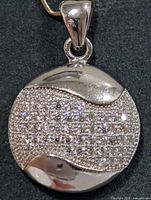 front view of round sterling silver pendant with CZ pave