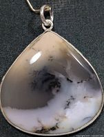 Front view of teardrop dendritic opal pendant in silver bezel