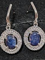 Front view of earrings showing sapphire centres and CZ halo
