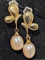 Front view of both earrings showing three-petal tops and pearl drops