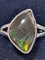 Top view highlighting freeform ammolite and bezel setting