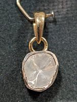 Front view of silver bezel-set rough diamond pendant with yellow-tone bail