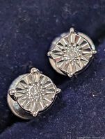 Front view of both stud earrings showing starburst settings and central diamonds