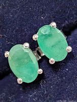 front view of both emerald earrings showing stones and prongs