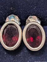 Front view showing oval faceted garnets in silver bezels