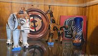 Group view showing elephant, giraffe, wood plate, wall art, ceramic vase
