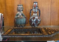 Both ceramic vases and inlaid mirror frame on glass surface