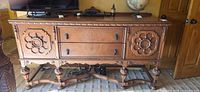 Full frontal view of sideboard showing carved panels, drawers, cabinets, legs, and top