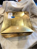 stack of square gold metallic charger plates