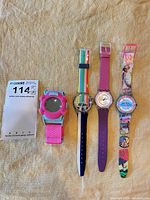 Group shot of all four Swatch wristwatches showing design variety and overall condition
