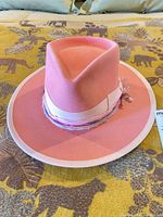 Top view of pink felt fedora showing crown shape, brim, ribbon and trim