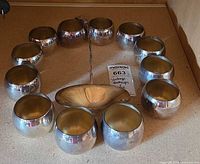 All 12 punch cups arranged in a circle with ladle at center, showing silver exteriors and gold interiors