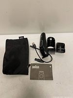 Complete kit laid out: trimmer, two guards, USB cable, pouch, manual