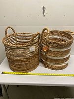 Two woven baskets side by side with tape measure showing height