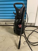 Front view of JobMate 1500 pressure washer with spray wand and power cord