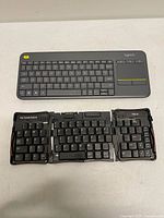 Logitech K400 Plus keyboard and Palm Portable Folding Keyboard fully opened
