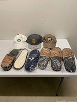 Three baseball caps and six pairs of slippers on table