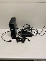 Front view of Xbox 360 S console, controller, power brick, cables