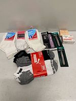 Grouped shot of all items: Puma sock pack, three diabetic sock pairs, grooming kit, tweezers, Dove soap, L’Occitane soap