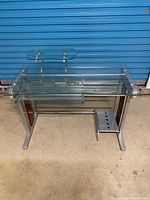 Full view of glass computer desk with monitor shelf and metal frame