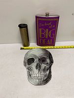 Overview showing flask, travel mug and skull plate with tape for scale