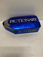 Blue metal pencil-shaped tin with Pictionary logo