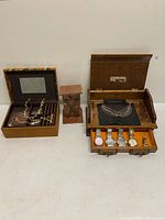 All items in lot displayed: jewelry box open with necklaces, small cabinet, watch chest with necklace and watches