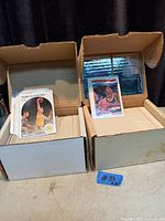Two open cardboard card boxes filled with hockey trading cards