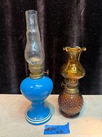 Two miniature vintage glass oil lamps: blue with clear chimney, amber hobnail with amber chimney