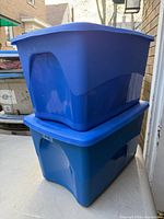 Two blue plastic totes stacked, showing side profile and lids