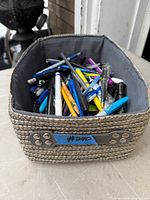 Overview of woven basket filled with assorted writing instruments