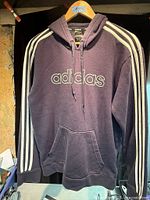 Front view showing logo, stripes, pocket, hood
