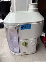 Side view of Braun juicer showing control dial, pulp container, feed tube