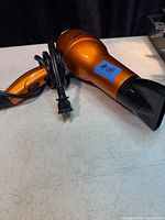 Full view showing orange Conair Infiniti Pro hair dryer with concentrator and cord