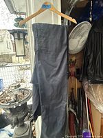 Dark blue coverall hanging on wooden hanger, front view
