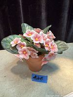 Artificial pink flowering plant in pot front view